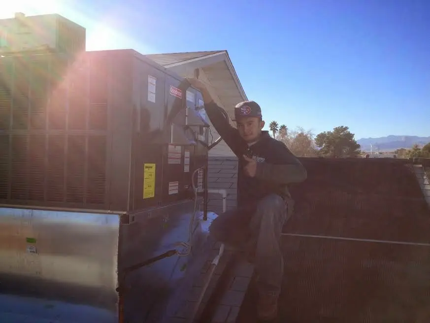 HVAC technician performing Air Duct Cleaning on a rooftop unit in St. Rose